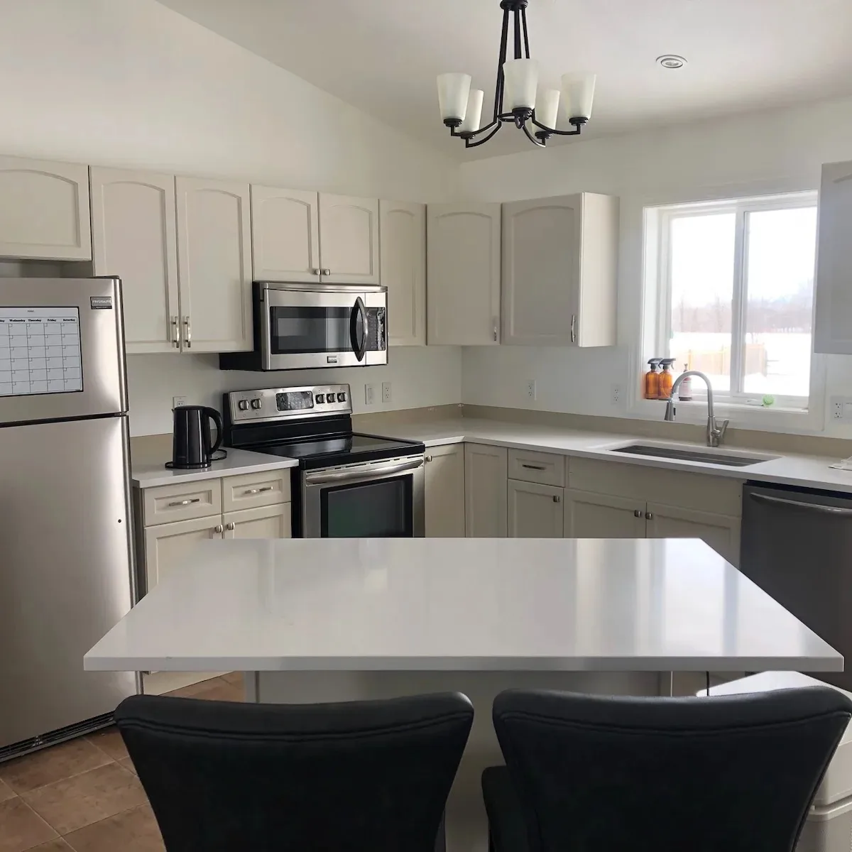 TAG cabinet refinishing: a welcoming kitchen with soft white cabinets and a bright island